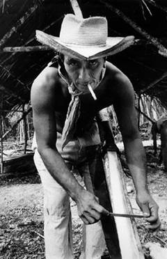 Diego afila su machete mientras espera la temporada de lluvias que comienza. Campamento Antonio Ay, 1977.
