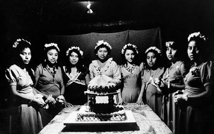 Junto a su pastel de 15 años Alicia se encuentra acompañada por sus damas. Chichimilá. 1976.