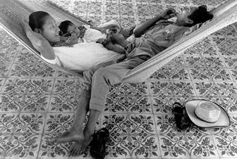 Fernando Puc Ché, su esposa y su hija comparten una hamaca. Ellos pasan mucho tiempo de su vida en la hamaca que es ideal para un clima tropical. Chichimilá, 1976.