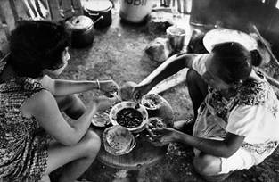 Veva y Alicia comparten un tazón de frijoles y usan su tortilla como cucharas. Chichimilá, 1976.