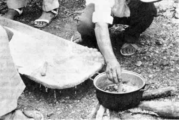 Elaboración de flor de cera en Cuncunul, Yucatán. Nótese la batea con agua y al señor en cuclillas con el molde en la mano.